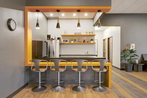 Indoor bar counter with stools and pendant lighting.