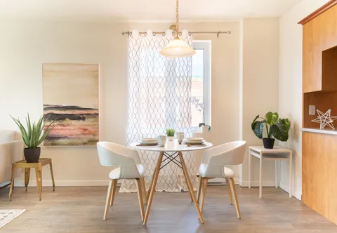 Kitchen and dining area with a round table and balcony doors.