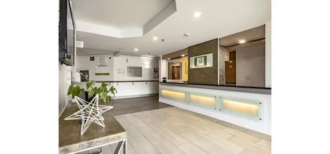 Lobby reception counter with noticeboards and a decorative plant.