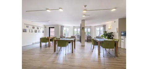 Activity room with tables, chairs and ceiling fans.