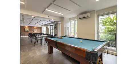 Billiard room with a pool table beside a seating area.