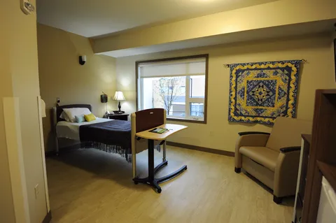 Bedroom with a bed, patterned wall quilt and bedside cabinets