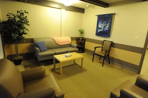 Sitting area with a grey sofa, black armchairs and a coffee table