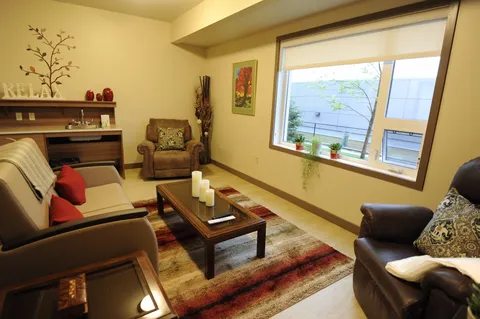 Bright sitting area with a sofa, two armchairs and a fireplace