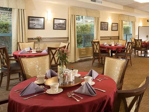Dining room with round tables and red tablecloths.