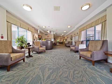 Wide corridor lounge with chairs and side tables.