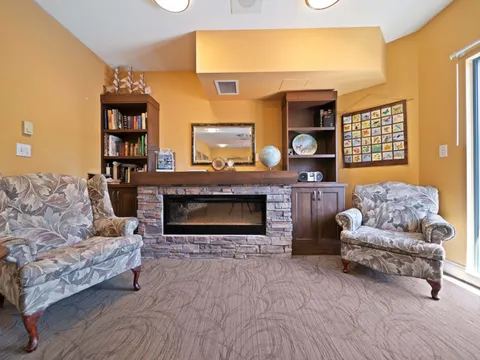 Lounge with sofas, a fireplace and bookshelves.