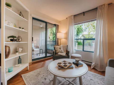 Suite sitting area with a chair, round table and balcony doors.