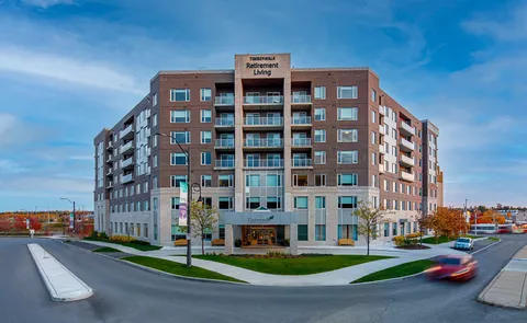Multi-storey residence exterior with balconies, covered entrance and roads.