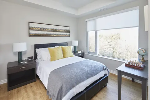 Bedroom with a double bed, two bedside tables, a desk and a window.
