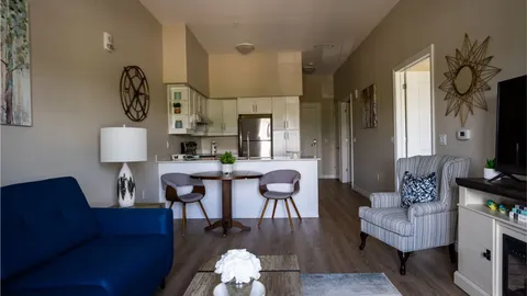 Suite living area with a sofa, armchair and breakfast counter.
