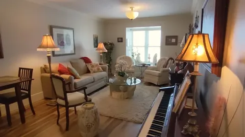Furnished sitting room with sofas, side tables and a piano.