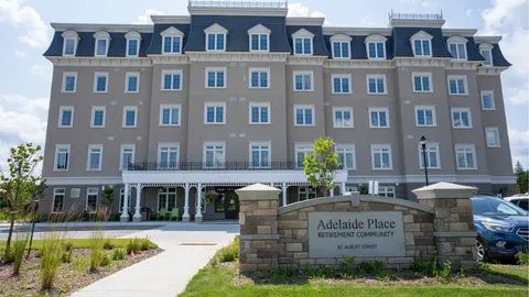 Residence facade with balconies, entrance doors and a stone sign.