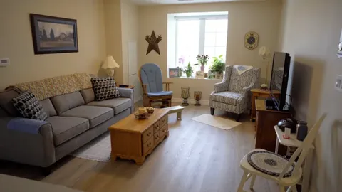 Furnished sitting room with a sofa, armchairs and a television.