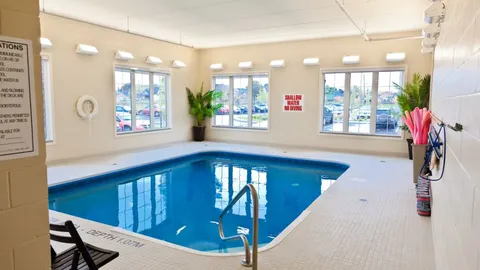 Indoor swimming pool beside large windows.