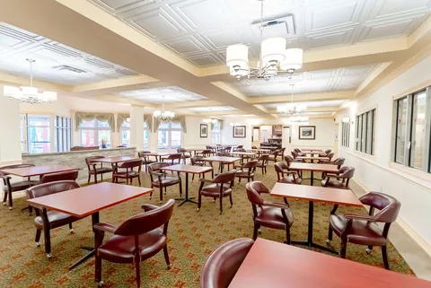 Dining room with wooden tables and chairs beneath a coffered ceiling
