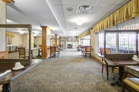 Dining room with tables and chairs beside large windows