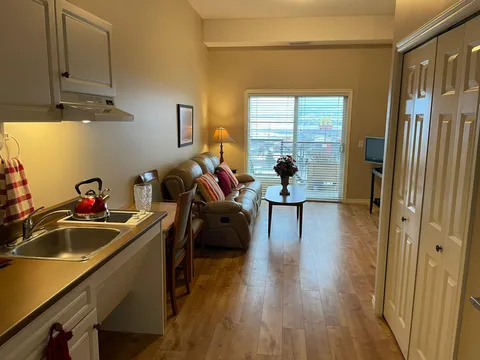Suite kitchenette with cabinets, a sink and adjacent seating.