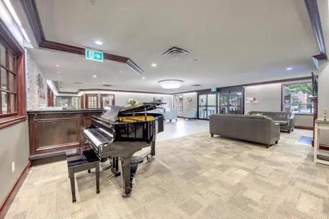 Lounge with sofas, armchairs, a grand piano and large windows