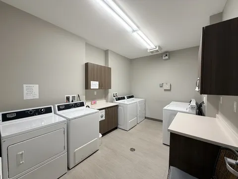 Laundry room with washers, dryers, cabinets and folding counters.
