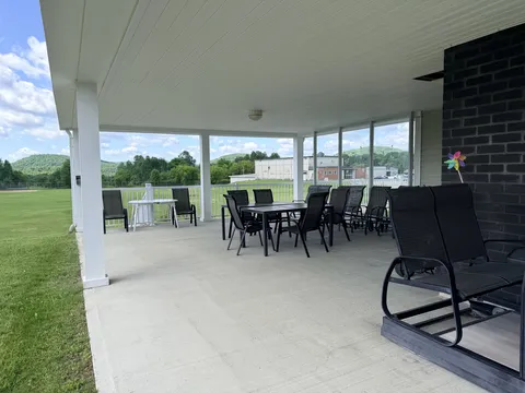 Covered terrace with tables, chairs and a garden swing.