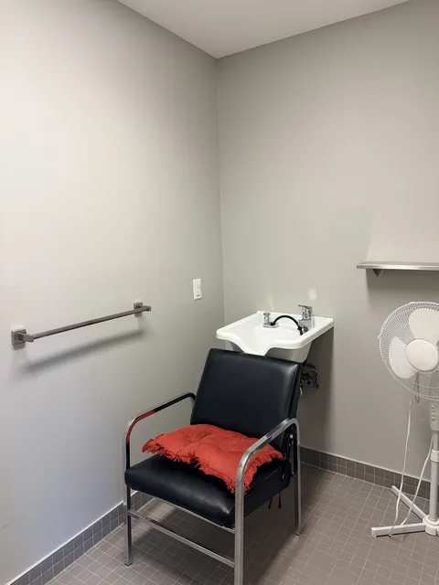 Salon wash station with a reclining chair and white hair-washing basin.