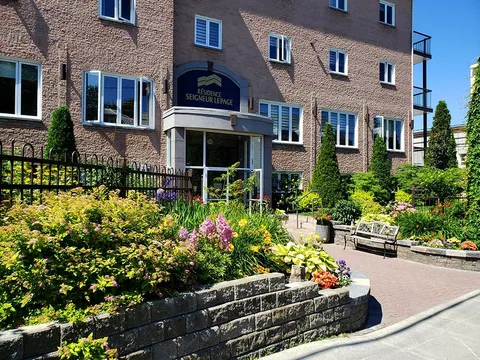 Brick residence entrance with balconies, windows and a covered doorway