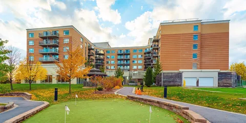 Rear exterior of the residence with balconies, a gazebo and a putting green