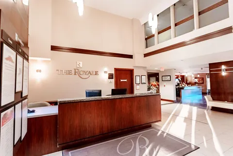 Reception desk beneath an open mezzanine with tiled flooring