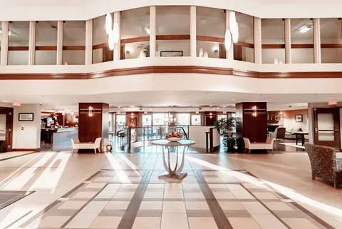 Lobby with a glass entrance, tiled floor, sofas and a central table
