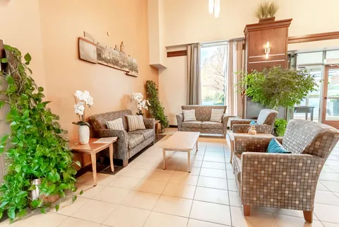 Seating area with a sofa, armchairs, plants and a cityscape wall hanging