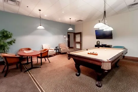 Games room with a billiards table, chairs and a blank television