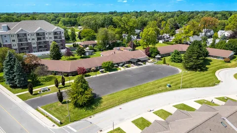 Aerial view of a low brick residence with a tiled roof and a driveway