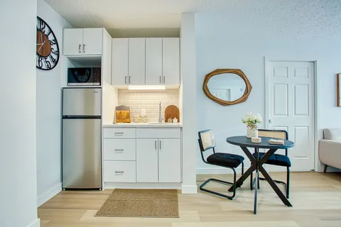 Suite kitchenette and dining table beside a large window.