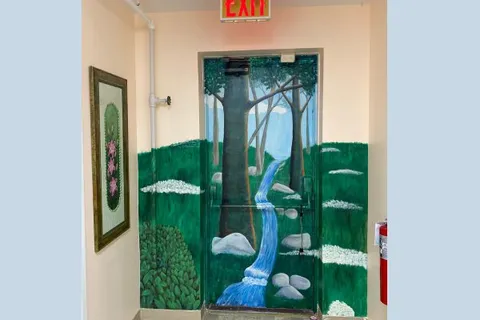 Interior exit door painted with a woodland stream.