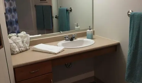Bathroom vanity with a sink, mirror, towels and shower curtain