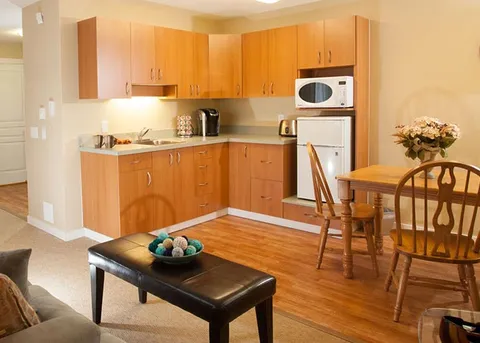 Suite kitchenette and dining area with wooden cabinets.