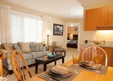 Suite living area with a sofa, dining table and kitchenette.