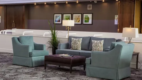 Atrium seating area with armchairs, sofas and a low coffee table.