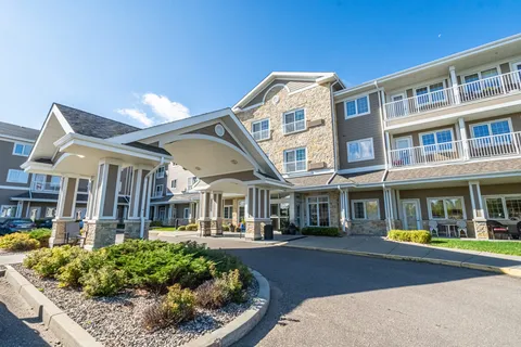 Three-storey residence with balconies, a covered entrance and landscaped planting beds