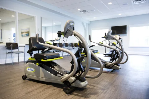 Exercise room with stationary machines, chairs and a wall-mounted television