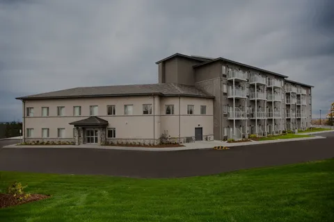Multi-storey residence with balconies, lawn and a paved driveway