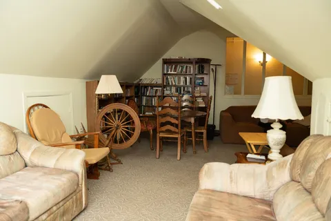Attic lounge with armchairs, sofas and bookshelves.