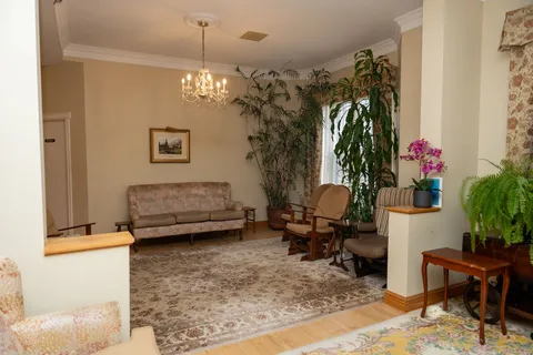 Entrance lounge with a chandelier, rocking chairs and sofas.