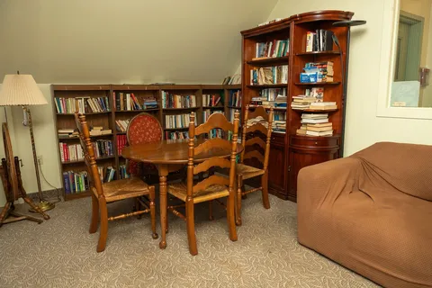 Library sitting room with a table and bookshelves.