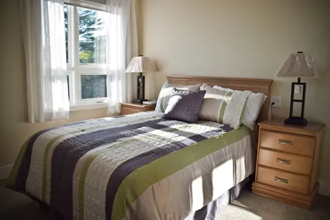 Bedroom with a double bed, wooden nightstands and a large window