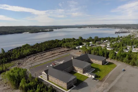 Aerial view of the residence and its parking area beside the water.