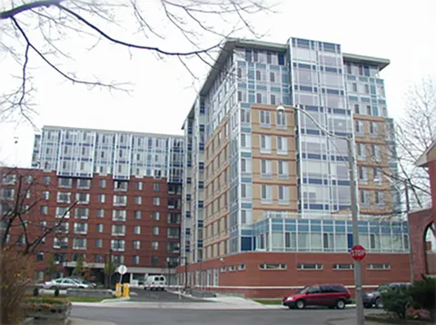 Multi-storey brick residence with glass balconies beside a street
