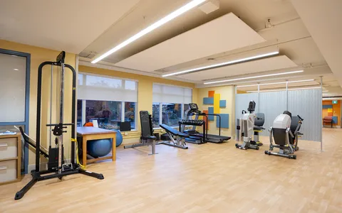 Fitness room with exercise machines and wooden flooring