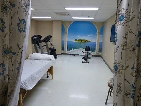 Exercise room with a treatment bed, fitness equipment and an island mural.